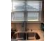 A stainless steel kitchen sink with modern faucet features double basin and view through window at 13709 Whitman Ln, Covington, GA 30014