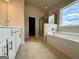 Bright bathroom featuring a soaking tub, glass enclosed shower, and ceramic tile flooring at 504 Clayborne Way # 248A, Loganville, GA 30052