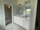 Bathroom featuring double sink vanity with white cabinetry, stylish mirrors and views of the bedroom at 504 Clayborne Way # 248A, Loganville, GA 30052