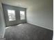 Bedroom with neutral walls, carpeted floors, and large windows overlooking the neighborhood at 504 Clayborne Way # 248A, Loganville, GA 30052