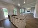 View of kitchen granite island and stainless faucet flowing into a bright living room with fireplace and laminate flooring at 504 Clayborne Way # 248A, Loganville, GA 30052