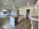 Bright kitchen featuring a granite island, stainless faucet, walk-in pantry and an open view into the living room at 504 Clayborne Way # 248A, Loganville, GA 30052
