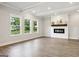 Bright living room with modern fireplace, hardwood floors, and large windows offering serene views at 504 Clayborne Way # 248A, Loganville, GA 30052
