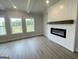 Cozy living room featuring a modern fireplace, sleek flooring, and scenic outdoor views at 504 Clayborne Way # 248A, Loganville, GA 30052