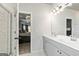 Bathroom with double sinks, a large mirror, and a glass-enclosed shower next to the entrance to the bedroom at 209 Osier Dr, Mcdonough, GA 30252