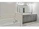 Bright bathroom featuring a soaking tub, marble accents, and modern vanity with dual sinks at 209 Osier Dr, Mcdonough, GA 30252