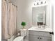 Well-lit bathroom features a vanity, mirror, and a shower with a decorative curtain at 209 Osier Dr, Mcdonough, GA 30252