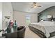 Stylish bedroom featuring dark accent wall, ceiling fan, window, and dark furnishings at 209 Osier Dr, Mcdonough, GA 30252
