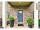 Inviting front entrance with gray door, brick facade, and potted ferns at 209 Osier Dr, Mcdonough, GA 30252