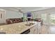 Open-concept living space with a kitchen island featuring granite countertops and stainless steel appliances at 209 Osier Dr, Mcdonough, GA 30252