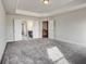 This bedroom boasts an elegant tray ceiling, an ensuite bathroom, and soft carpet at 714 Bristol Dr # 279A, Loganville, GA 30052
