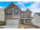 Two-story home with brick and stone accents, two-car garage, and manicured front yard at 714 Bristol Dr # 279A, Loganville, GA 30052