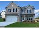 Beautiful two-story home featuring stone and gray shingle accents, a two-car garage, and manicured landscaping at 714 Bristol Dr # 279A, Loganville, GA 30052