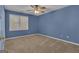 Bedroom featuring blue walls, neutral carpet, a ceiling fan, and a bright window at 81 Bowers Rd, Moreland, GA 30259