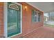 Cozy porch features a classic brick exterior, a green front door, and decorative shutters for a welcoming entrance at 81 Bowers Rd, Moreland, GA 30259
