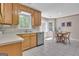 Open kitchen area with stainless dishwasher, wood cabinets, and adjacent dining area at 81 Bowers Rd, Moreland, GA 30259