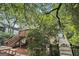 Backyard view with a wooden deck, stairs, and a charming brick patio surrounded by lush greenery at 1718 Ridgewood Ne Dr, Atlanta, GA 30307