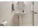 Elegant bathroom featuring a pedestal sink, round mirror, and brushed nickel fixtures, creating a serene atmosphere at 1718 Ridgewood Ne Dr, Atlanta, GA 30307
