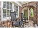 Inviting front porch with rocking chairs, brick arch, and tiled flooring at 1718 Ridgewood Ne Dr, Atlanta, GA 30307