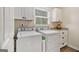 Bright laundry room with white cabinets, granite countertops, and modern washer and dryer set at 1718 Ridgewood Ne Dr, Atlanta, GA 30307