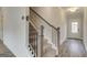 Staircase featuring carpeted steps, wooden banisters, and modern iron spindles, complemented by wood floors in the entryway at 402 Westmarch Cir # 285A, Loganville, GA 30052