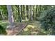 Backyard view showcasing lush landscaping, tall trees, and a brick-lined walkway through the green space at 4710 Cedar Brook Se Dr, Conyers, GA 30094