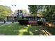 Exterior view of a backyard with an attached wooden deck, spacious lawn, and mature trees at 4710 Cedar Brook Se Dr, Conyers, GA 30094