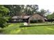 Charming brick home featuring lush green lawn, mature trees, and meticulous landscaping, radiating curb appeal at 4710 Cedar Brook Se Dr, Conyers, GA 30094