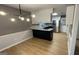 Kitchen and dining area featuring modern light fixture, decorative wall pattern, and wood floors at 4710 Cedar Brook Se Dr, Conyers, GA 30094