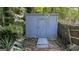 Exterior view of backyard storage shed, painted gray, with wooden plank path leading up to the door at 4710 Cedar Brook Se Dr, Conyers, GA 30094