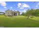 Expansive backyard with a gentle slope, lush green grass, mature trees and patio at 9360 Ward Rd, Winston, GA 30187