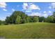 Large, grassy backyard with mature trees; recreational vehicle visible in distance at 9360 Ward Rd, Winston, GA 30187