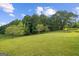 Grassy backyard with scattered trees and park benches at 9360 Ward Rd, Winston, GA 30187