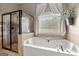 Elegant bathroom with a jacuzzi tub, a large window, and a tiled glass shower at 9360 Ward Rd, Winston, GA 30187
