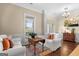 Bright living room with hardwood floors, white sofas, and a view through the window at 9360 Ward Rd, Winston, GA 30187