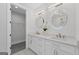 Bathroom with double sink vanity, white cabinets, modern fixtures and circular framed mirrors at 101 Fairfield Nw Pl, Atlanta, GA 30314