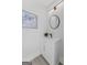 Powder room featuring a white vanity with a dark faucet, round mirror, and contemporary decor at 101 Fairfield Nw Pl, Atlanta, GA 30314