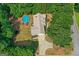 Aerial view of a home with a pool, long driveway, and surrounded by mature trees at 116 Alexander Dr, Mcdonough, GA 30252