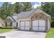 Side view of a two-car garage with stone accents matching the house, plus ample driveway parking at 170 Saddleridge Dr, Bremen, GA 30110
