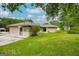 View of detached garage with a large parking area, grassy lawn, and greenery of the home's backyard at 741 Greenhill Ne Dr, Conyers, GA 30012