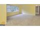 The home's bright living room features neutral carpet, large windows, and is painted in a light neutral color at 741 Greenhill Ne Dr, Conyers, GA 30012