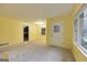 Bright living room with neutral carpet and a view into other rooms and with a front door and large windows at 741 Greenhill Ne Dr, Conyers, GA 30012