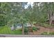 Aerial view of a stunning backyard featuring a pool, patio with dining set, and meticulously landscaped gardens at 115 Shoal Creek Dr, Sharpsburg, GA 30277