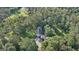 Aerial view of a home surrounded by forest; a lake is visible in the distance at 115 Shoal Creek Dr, Sharpsburg, GA 30277