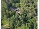 A home and driveway are nestled in a dense forest, aerial view at 115 Shoal Creek Dr, Sharpsburg, GA 30277