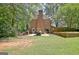 Brick house exterior with a golf cart parked on the patio next to a neatly maintained lawn and mature trees at 115 Shoal Creek Dr, Sharpsburg, GA 30277