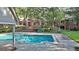 Scenic backyard view with a large swimming pool, brick surround, manicured lawn, and brick house facade at 115 Shoal Creek Dr, Sharpsburg, GA 30277