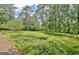 Lush backyard with manicured landscaping, mature trees, and brick pathways create a serene outdoor space at 115 Shoal Creek Dr, Sharpsburg, GA 30277