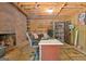 Unfinished basement featuring a brick fireplace, desk area, and exposed ceiling beams at 115 Shoal Creek Dr, Sharpsburg, GA 30277