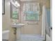 Bathroom with blue floor tiles, pedestal sink, and shower/tub with curtain at 115 Shoal Creek Dr, Sharpsburg, GA 30277